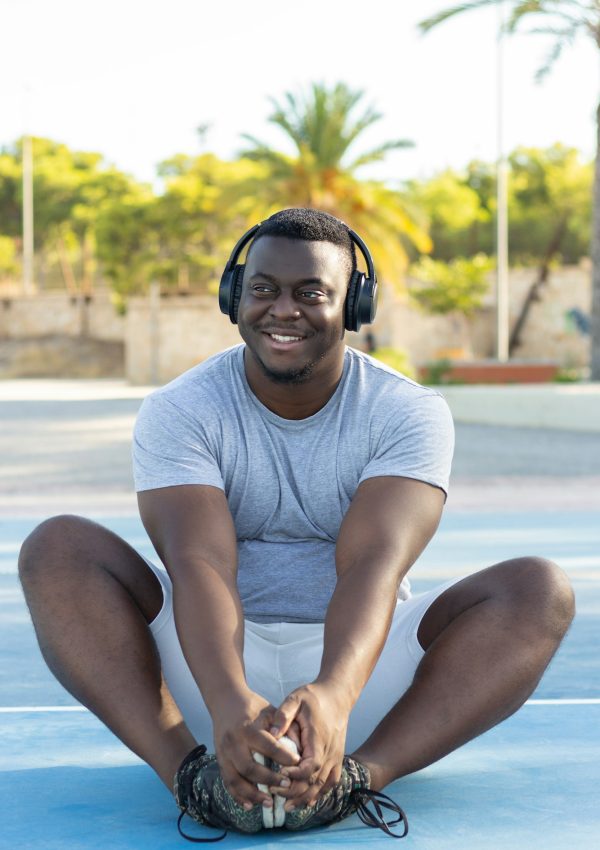 Young black male in headphones working out in a park